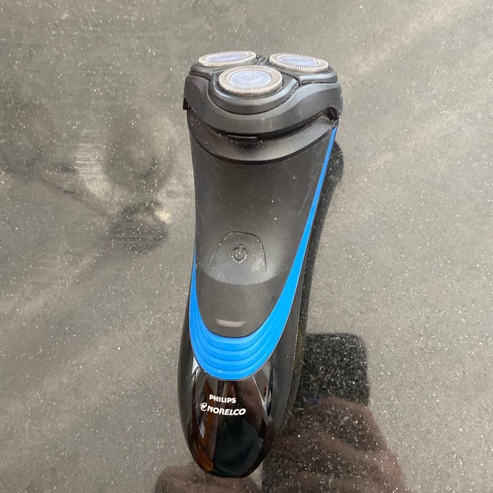 Used Phillips Norelco three headed electric razor with trimmer on back, wet dry